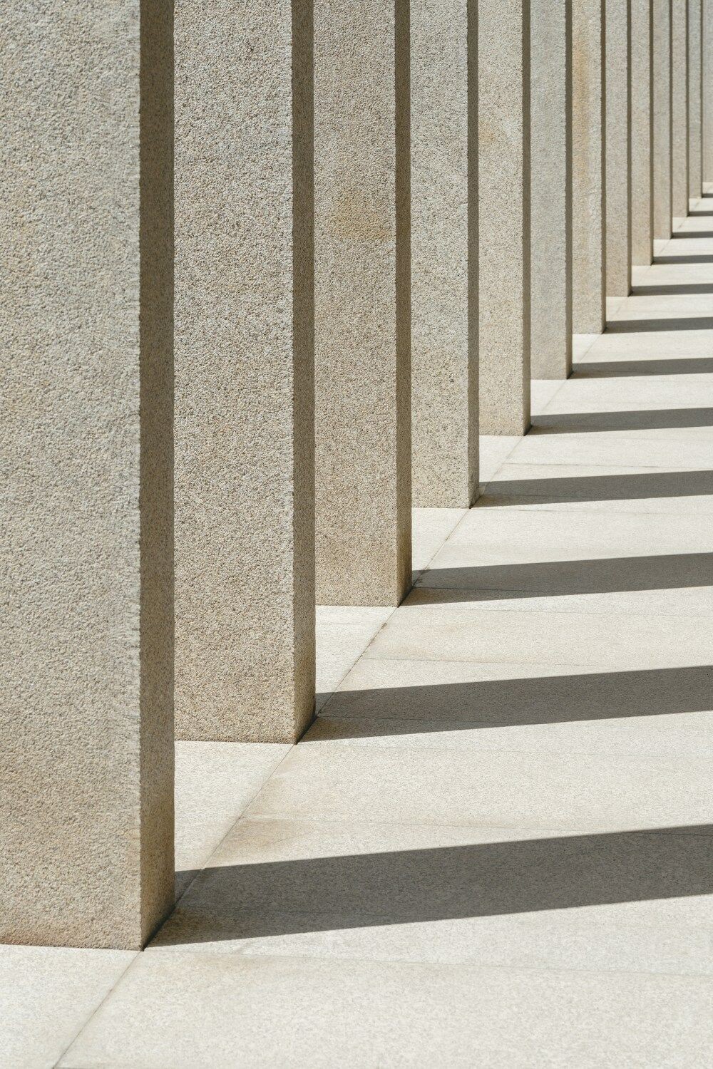 Stone colonnade casting long shadows